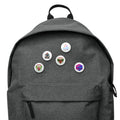 Flat-lay product display of the Apres Leisure Vanguard OG Button 5-Pack accessory set featuring ecosystem graphic assets on backpack (sizes vary).
